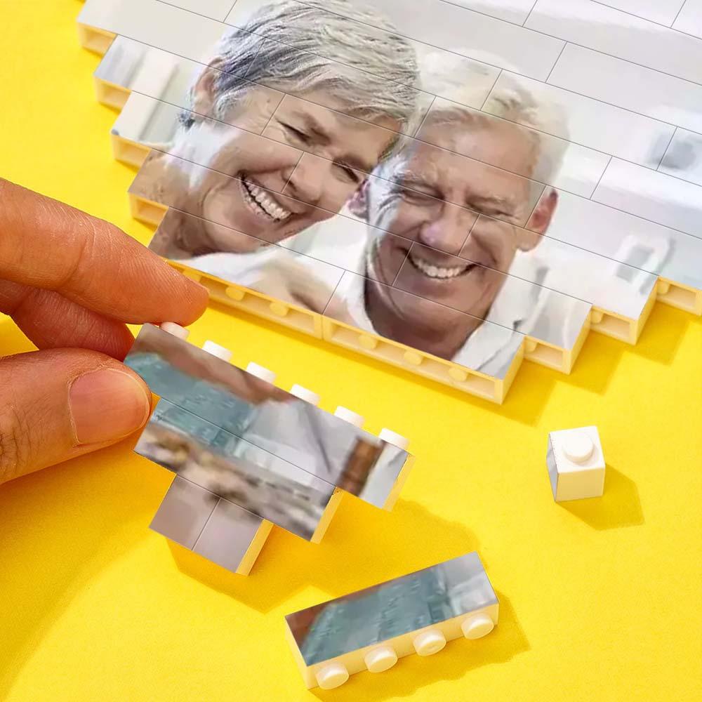 Assembling personalized heart-shaped photo block puzzle with elderly couple, DIY gift, interlocking bricks, vibrant colors.